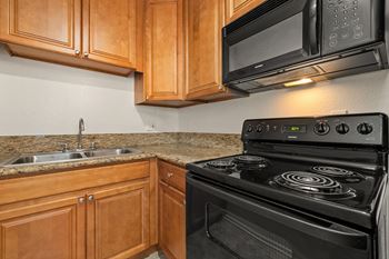 a kitchen with a stove and a sink and a microwave at Topanga Canyon Apartments, West Hills, California